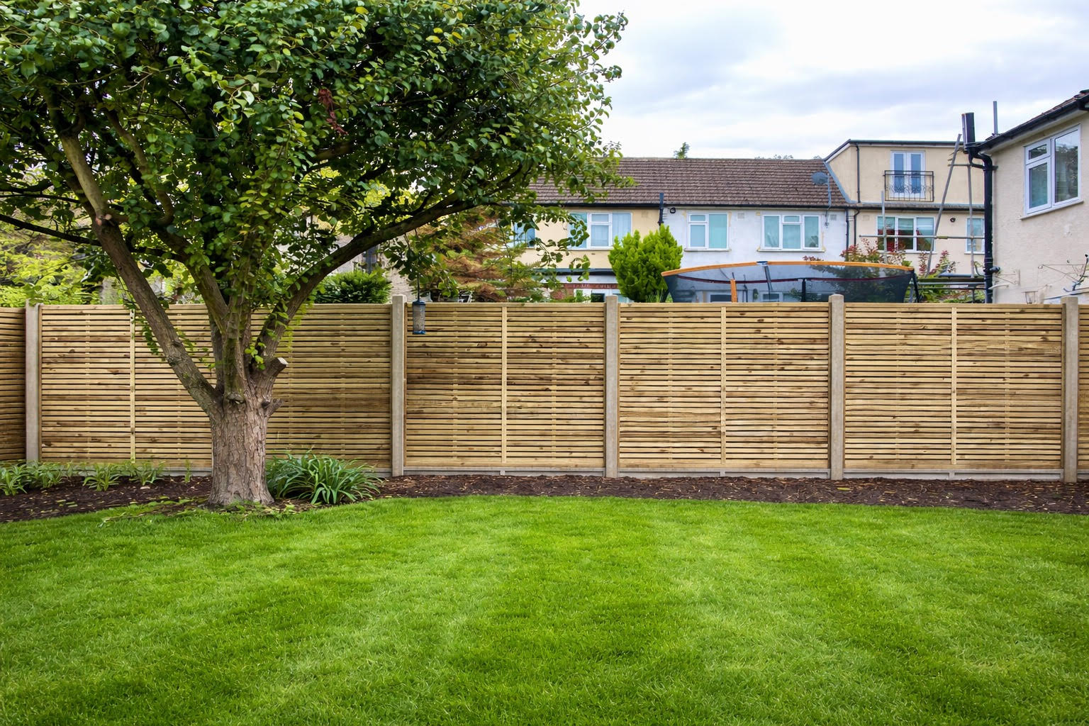 Timber fence panels beside a green lawn
